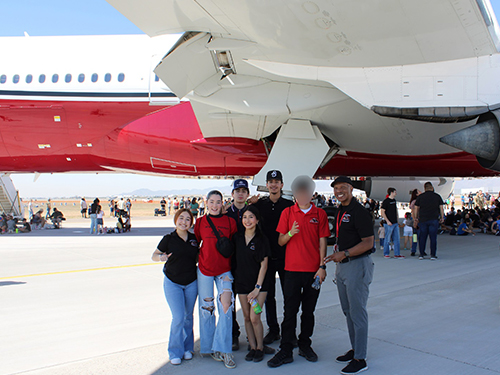 students and Mr. Washington pose for a group photo in front of the Arizona Cardinal’s private jet